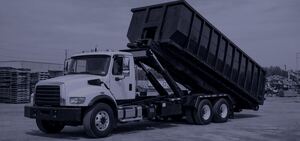 Roll-off truck lifting a dumpster container